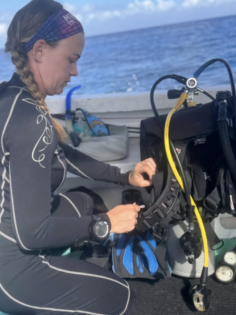Diver kneeling in shallow water practicing scuba skills with equipment to ease dive anxiety