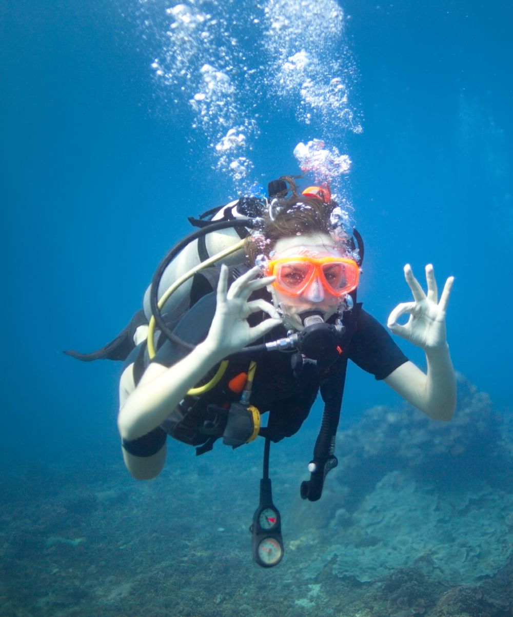 diver testing scuba mask seal underwater in shallow water to check for leaks and proper fit