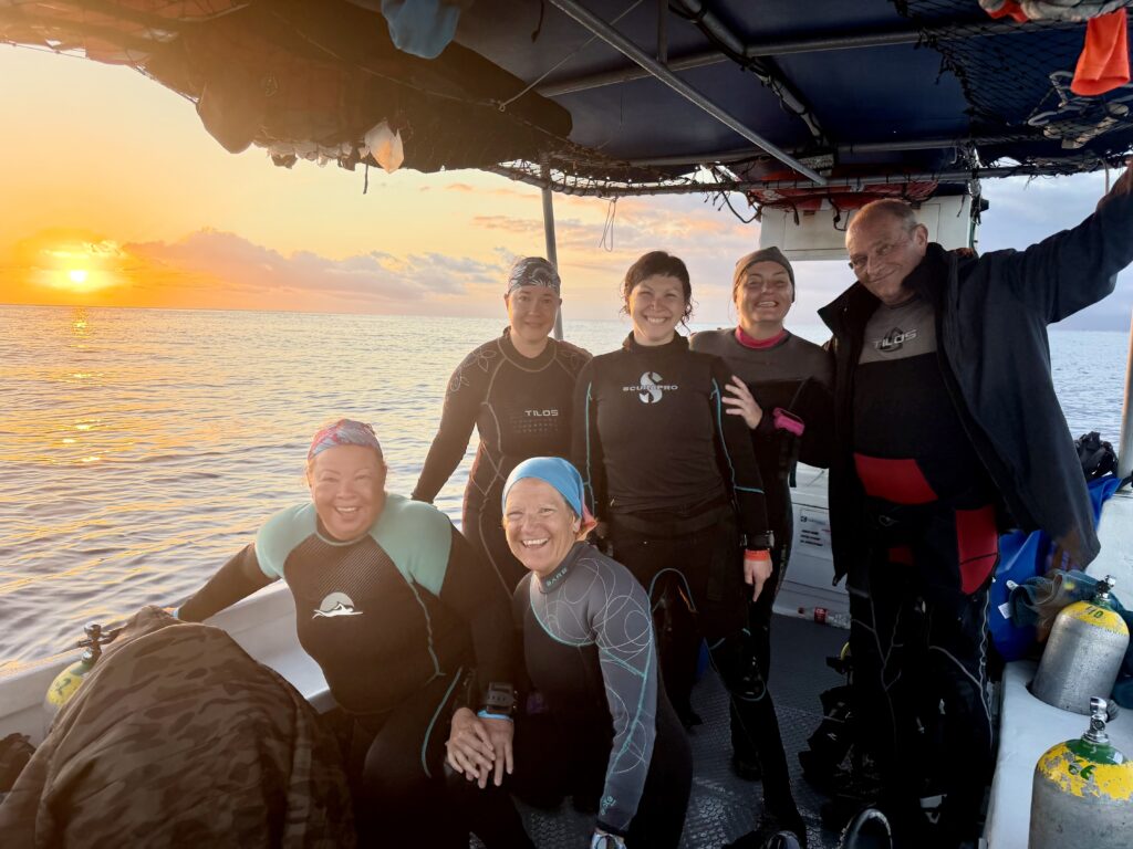 Group of women scuba divers smiling on a boat after a drift dive in Cozumel