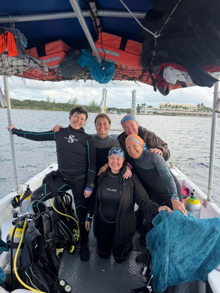 Group of women scuba divers preparing gear on a boat in the Philippines