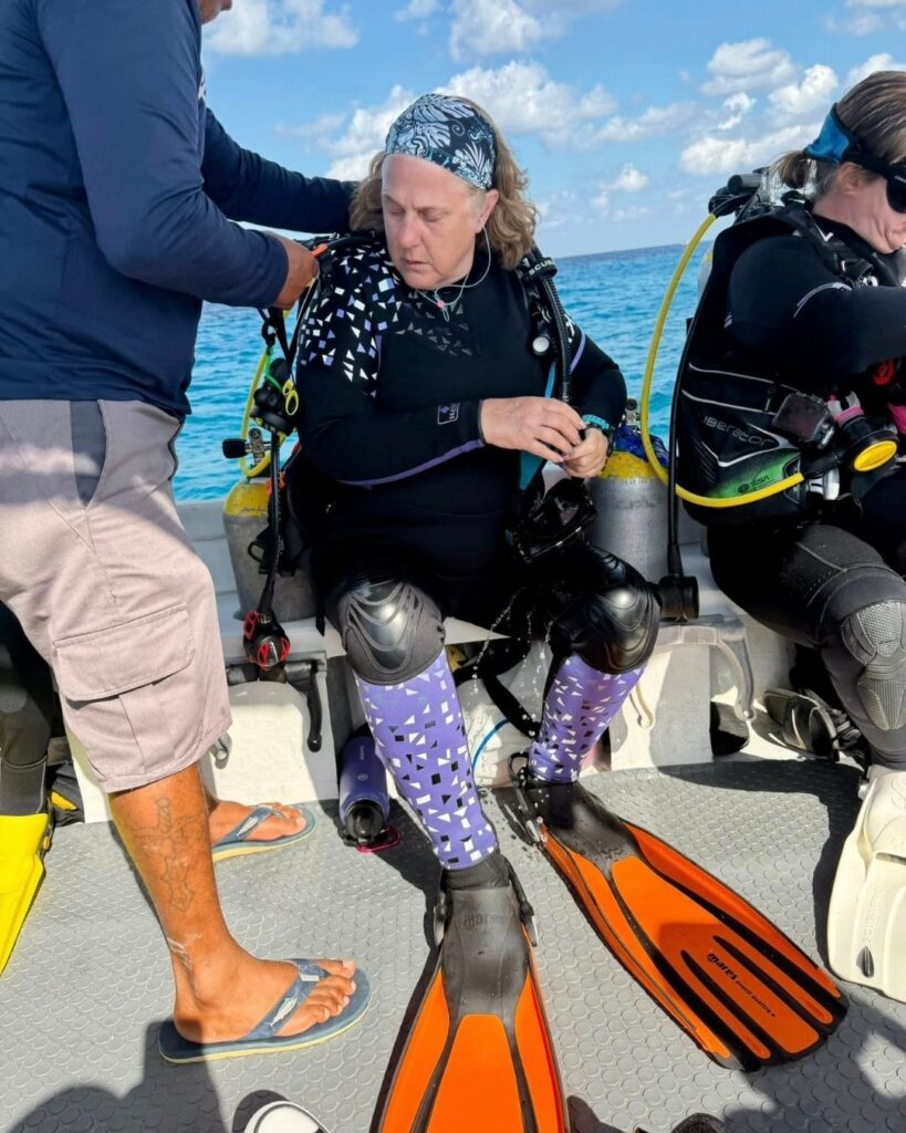 Women over 50 preparing scuba gear on a dive boat in Bonaire