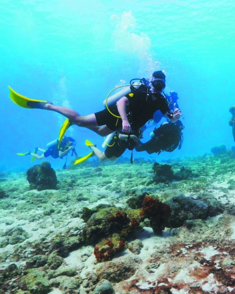 Scuba diver over 50 in Bonaire with clear visibility and visible reef
