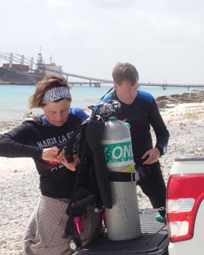 Shore diving in Bonaire diver preparing gear from truck on beach